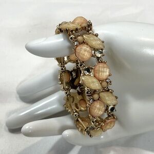 Gold Tone bracelet with light pinks and cream colored jewels and rhinestones.